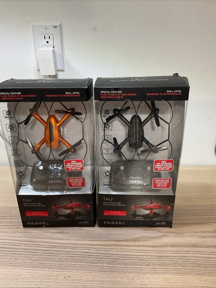 Palm-sized performance drone in retail box, orange and black propellers