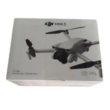DJI Mini 3 drone unit with gray body and three propellers, shown on box