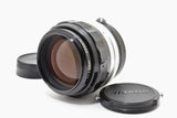 Manual focus camera lens with black metal body, front glass and NIKKOR cap