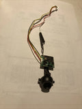Drone camera module with circuit board, black lens, and colored wiring