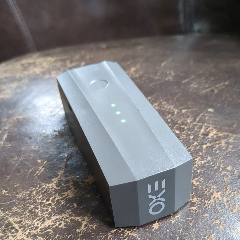 Gray rectangular drone battery pack with LED status lights and handle slot