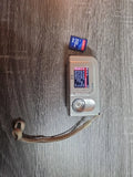 Silver HP PhotoSmart E217 digital camera with lens, buttons, and front panel