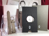 Men's round analog wristwatch with white dial and brown leather strap, shown on card