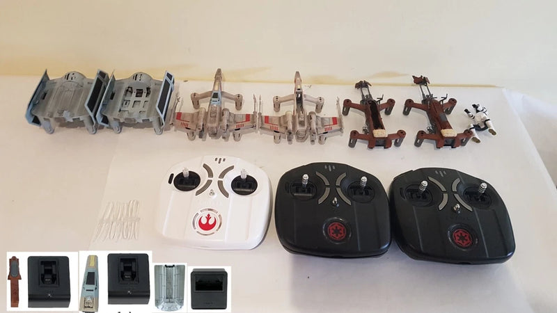 Drone parts set with two black controllers, one white remote, and assorted components