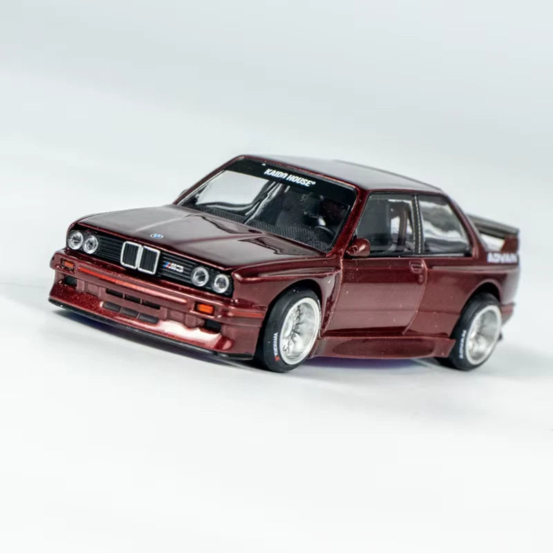 Burgundy die-cast 1/64 BMW M3 E30 model car with detailed front grille and headlights