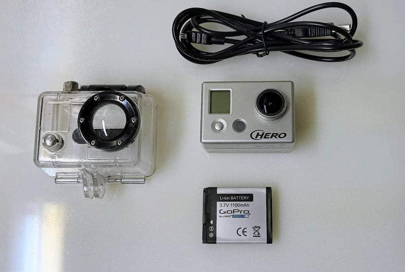 GoPro HERO action camera kit with waterproof housing, silver camera unit, battery and cable