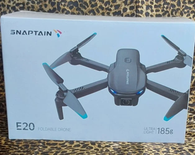SNAPTAIN E20 foldable drone shown with four blue propeller blades on retail box