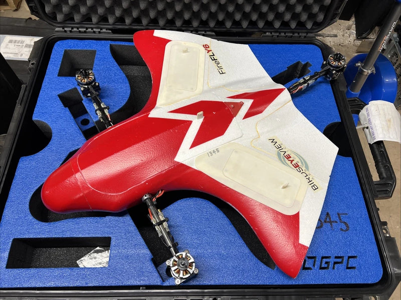 Red and white hybrid UAV drone with four propellers in a hard case