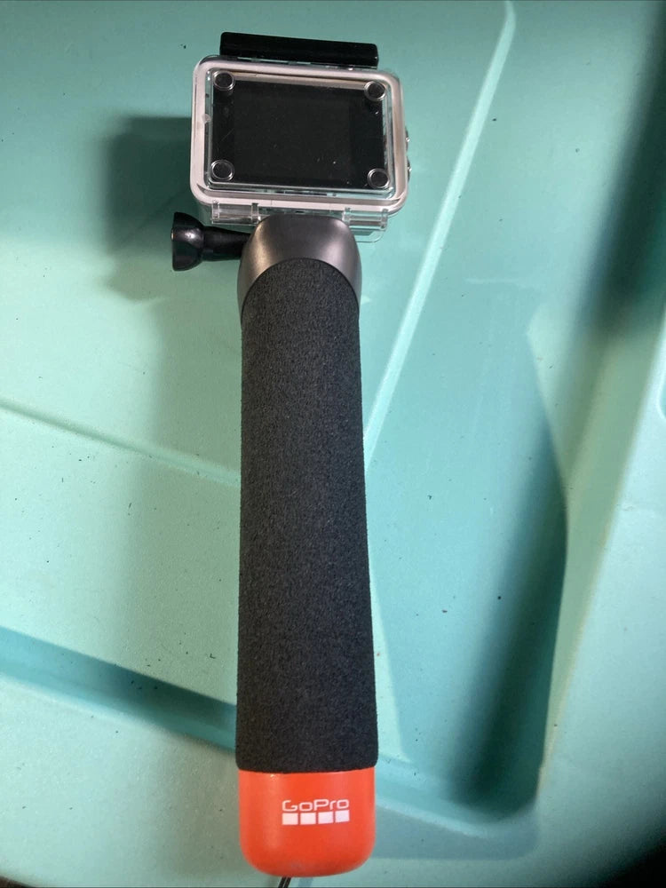 GoPro action camcorder in clear housing with black grip and red base