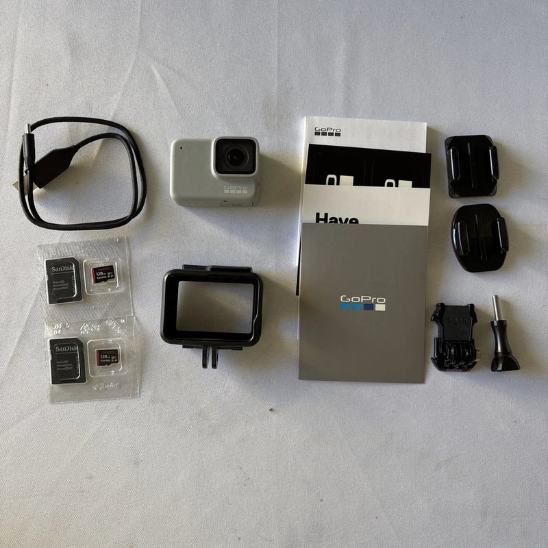 White GoPro HERO 7 action camera kit with mounts, clips, batteries and case
