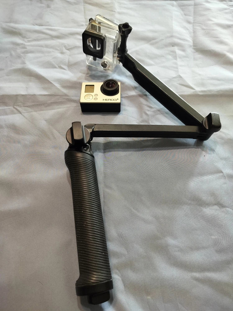 GoPro HERO 3+ action camera with black selfie stick, mounted and tilted