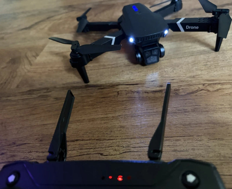Quadcopter drone with HD camera and blue LEDs, shown with remote controller