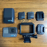 GoPro HERO6 Black action camera with waterproof housing and mounting accessories, shown top view