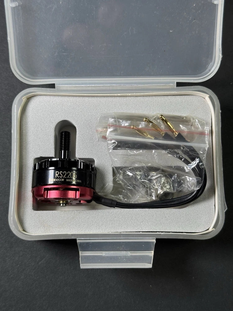 RS2205 brushless drone motor with red rotor and black leads in plastic bag