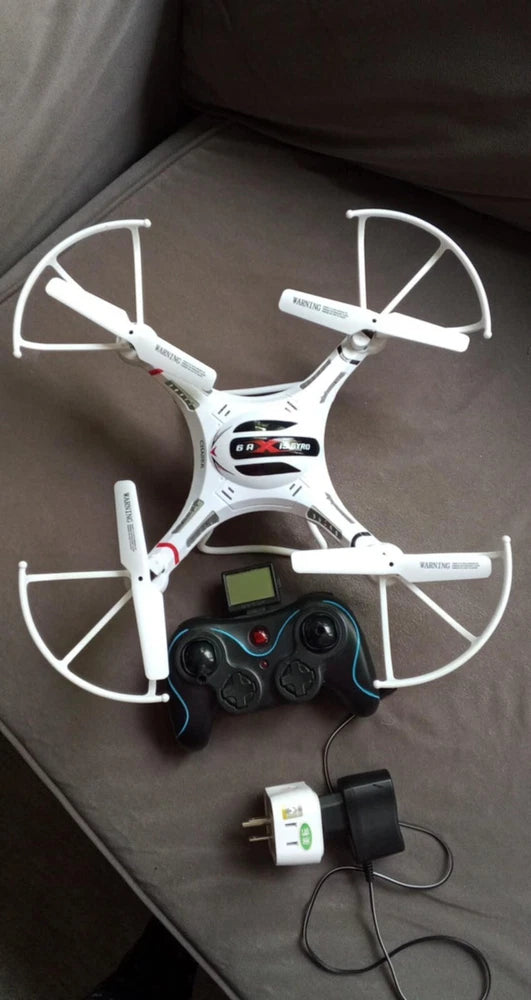 White 2.4 GHz quadcopter drone with four propellers and handheld remote controller