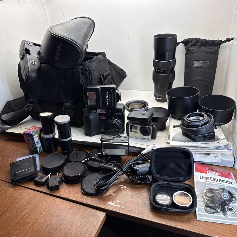Vintage action camera lot with lenses, caps, pouches, and multiple cameras