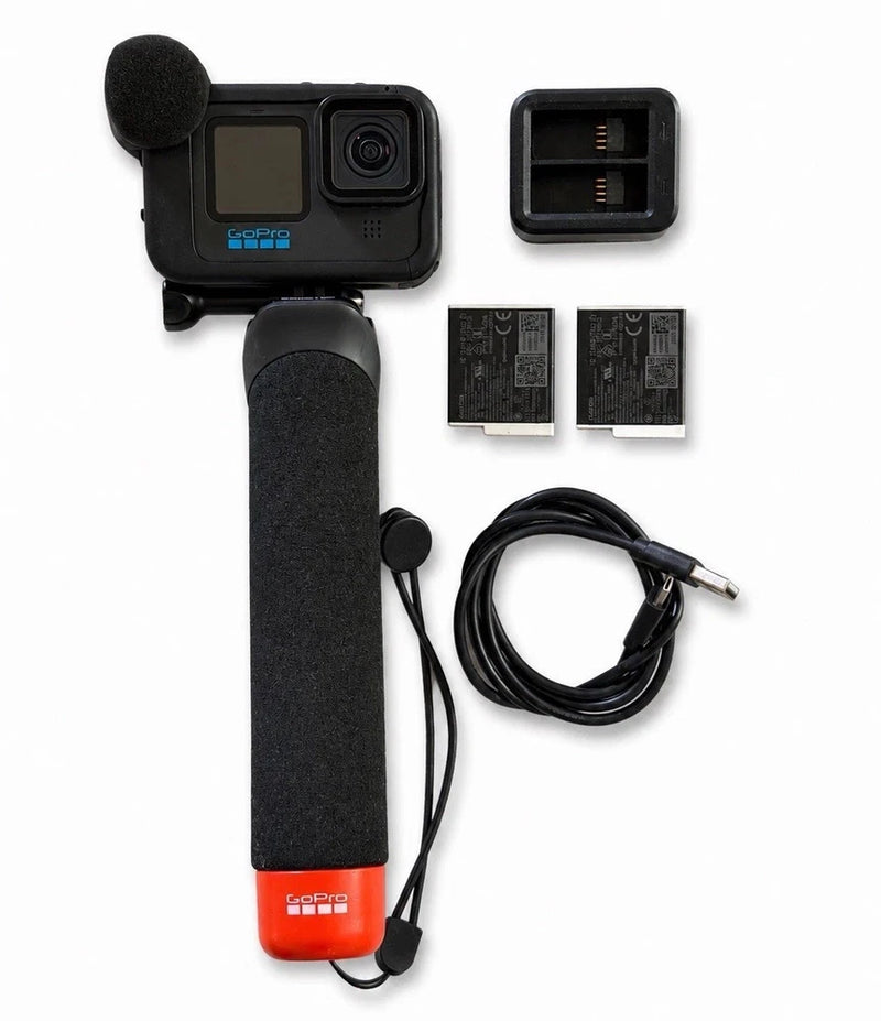 Black action camera with media mod grip, dual batteries, and charging cable