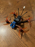 FPV quadcopter drone with four orange propellers and two black antennas