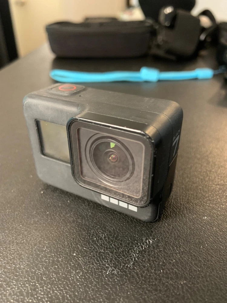 Black action camera with front lens and touchscreen display, in protective case