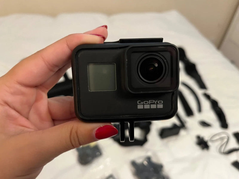 GoPro HERO7 Black action camera with front lens and LCD screen, held in hand