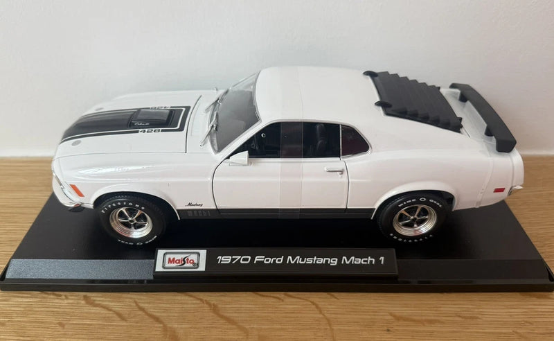 1970 Ford Mustang Mach 1 white die-cast model car, front three-quarter view on base