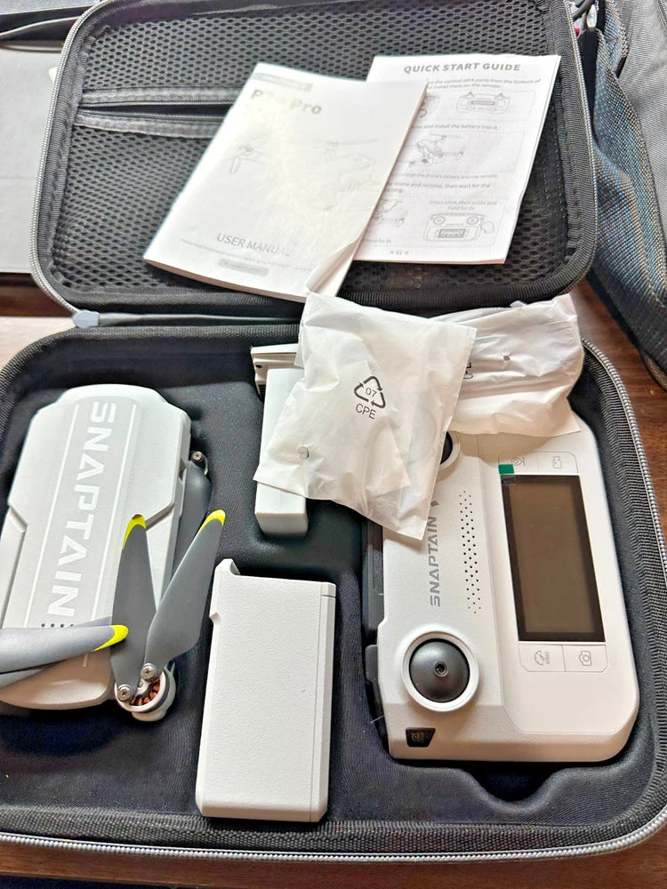 Gray GPS drone with remote controller and charging accessories in a hard carry case