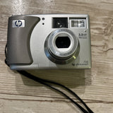 Silver HP PhotoSmart 735 digital camera with zoom lens and rear control panel