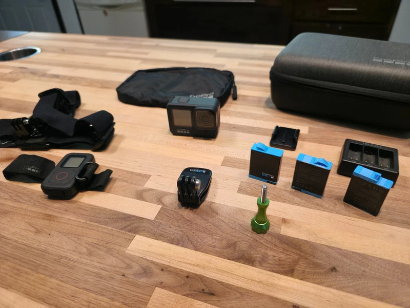 Action camera kit with small camera, remote, mounts, and black cases