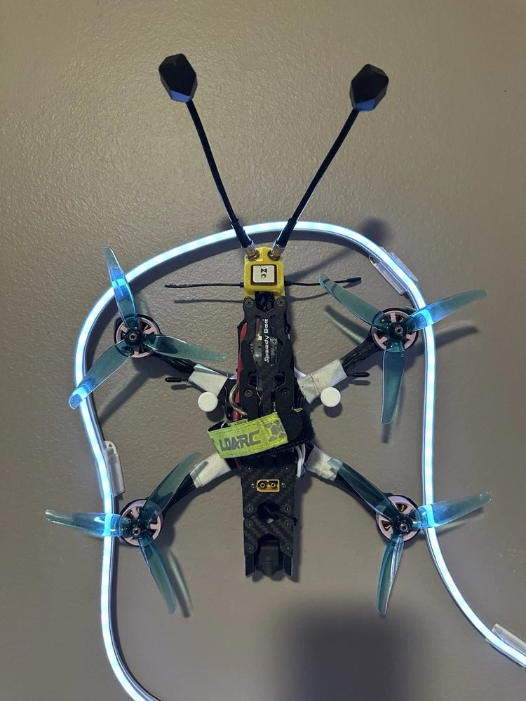 Custom FPV drone with ring frame, four propellers, blue LEDs, central flight controller