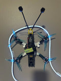 Custom FPV drone with ring frame, four propellers, blue LEDs, central flight controller
