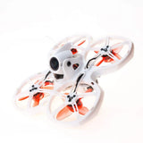 Indoor FPV racing drone with white frame and four orange propellers, compact quadcopter