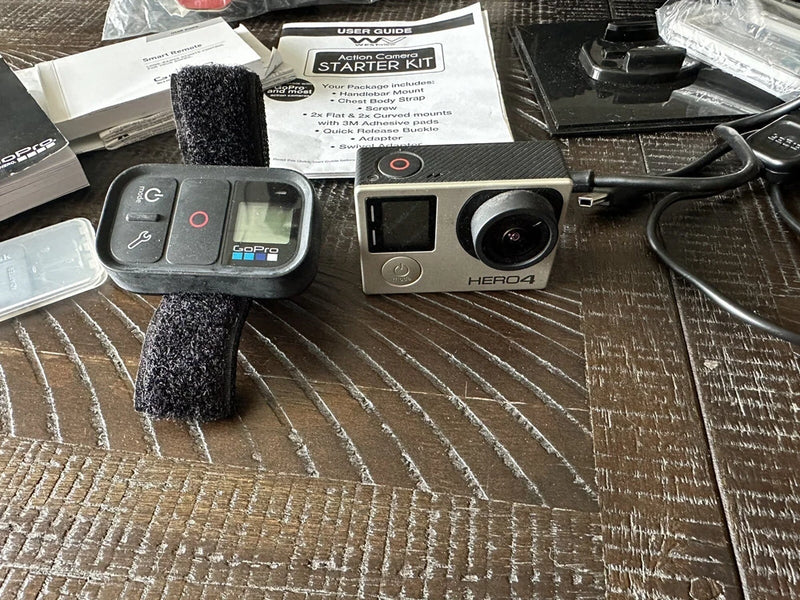 GoPro HERO4 action camera with silver housing and lens, with bundled accessories