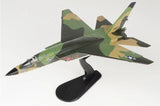 Camouflage military jet model with four-blade stand, green and tan with dark accents