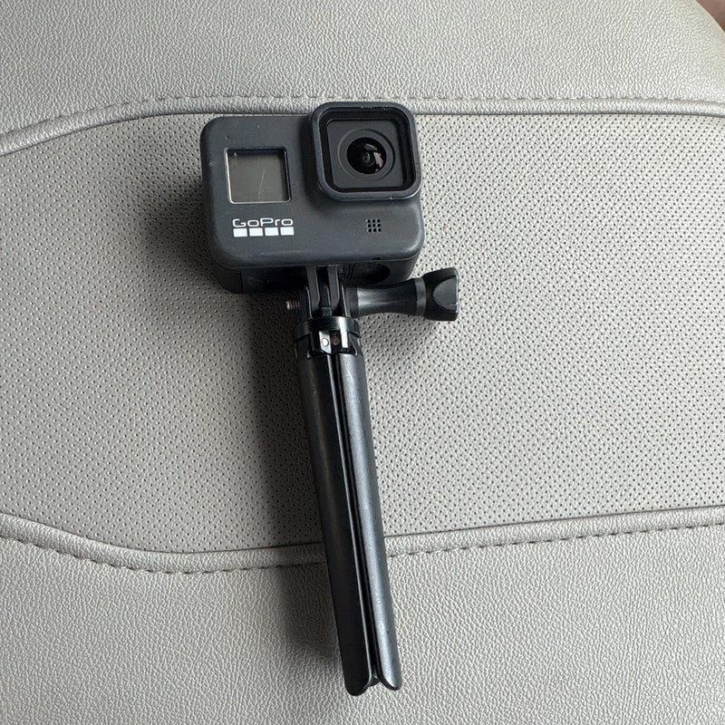 GoPro HERO8 Black action camera on tripod mount, front lens and side buttons visible