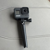 GoPro HERO8 Black action camera on tripod mount, front lens and side buttons visible