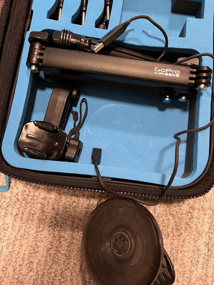 GoPro HERO Session action camera with handle mount and cables, on case