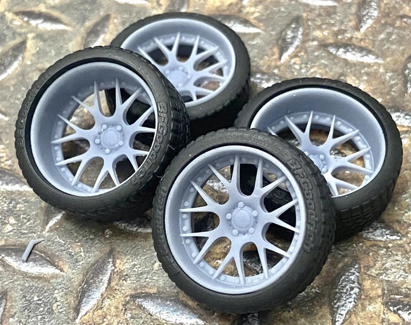 Set of three model car wheels with silver multi-spoke rims and dark tires
