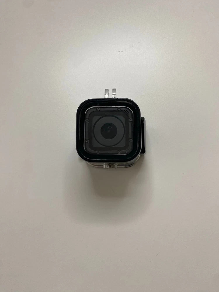 Black action camera in protective waterproof housing with visible front lens window