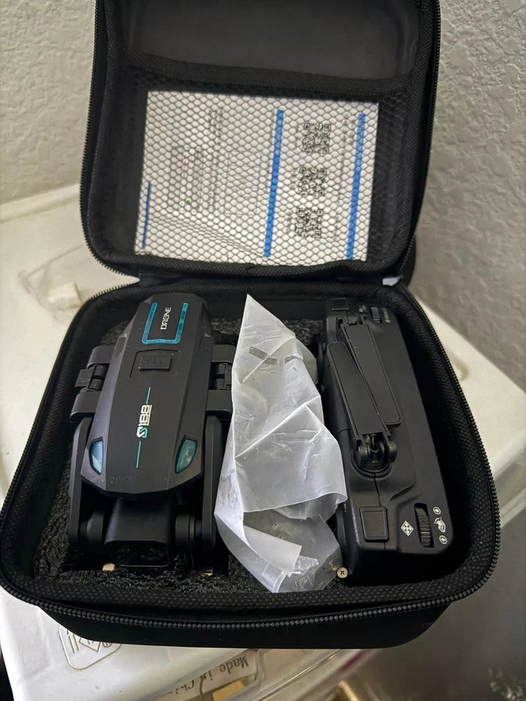 Foldable black drone with camera in open protective case
