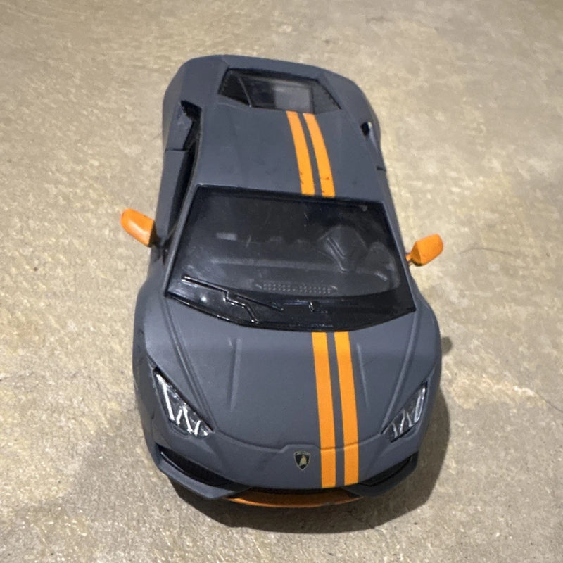 Grey sports car model with orange racing stripes and front headlights