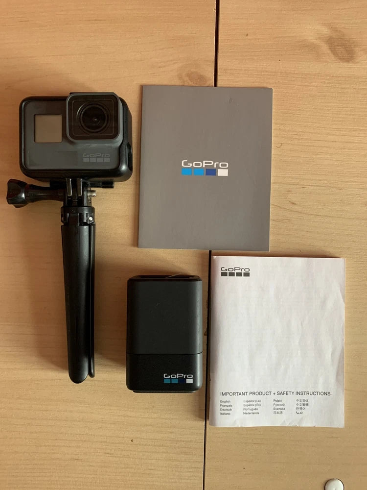GoPro HERO5 action camera bundle with camera, mount, handle, and instruction manuals