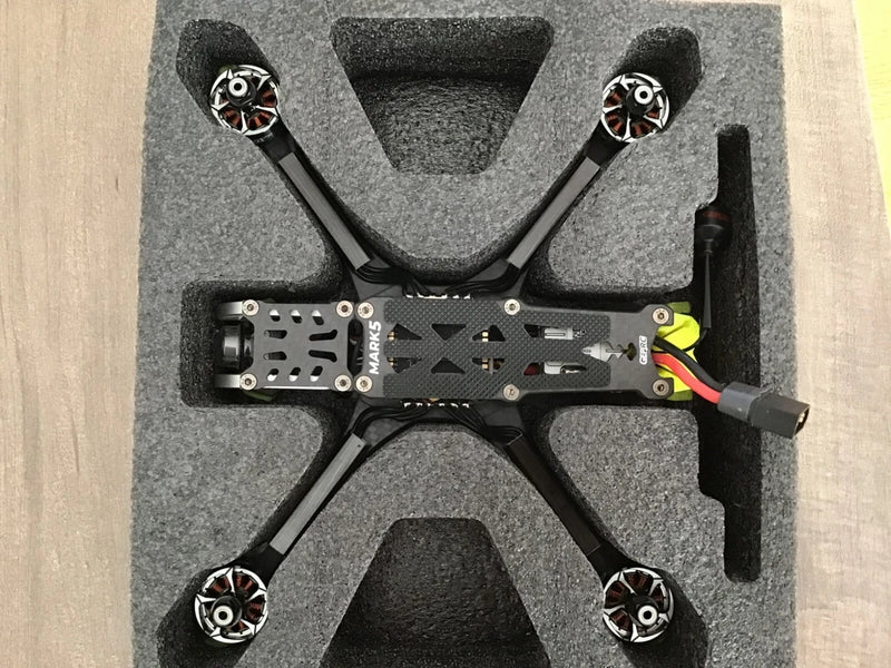 Black FPV drone with four arms and propellers, top view of the Mark5 HD frame
