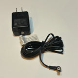 Black AC adapter with two-prong plug and yellow-tip DC barrel connector cable