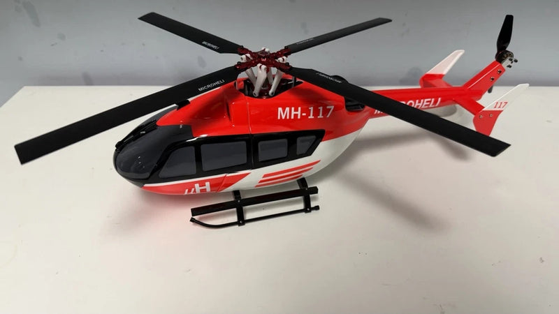 Red and black RC scale helicopter with four-blade rotor and landing skids