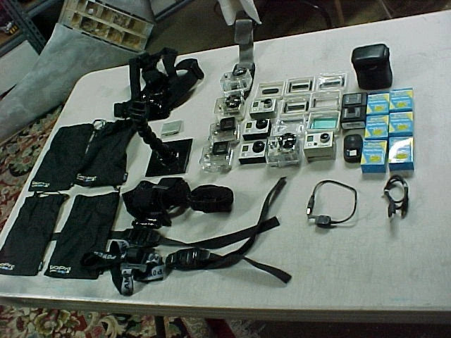 Silver action camera bundle with several mounts, straps, and charging accessories