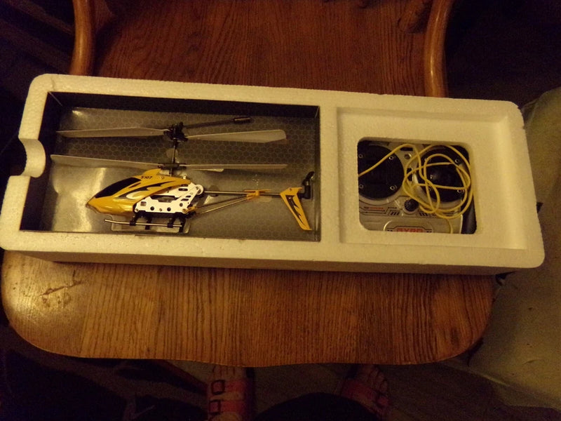 Mini yellow quadcopter drone helicopter with rotor, in foam packaging tray