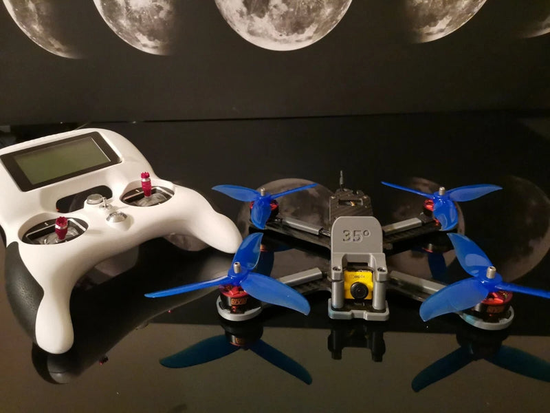 FPV freestyle drone quadcopter with blue propellers and white remote controller