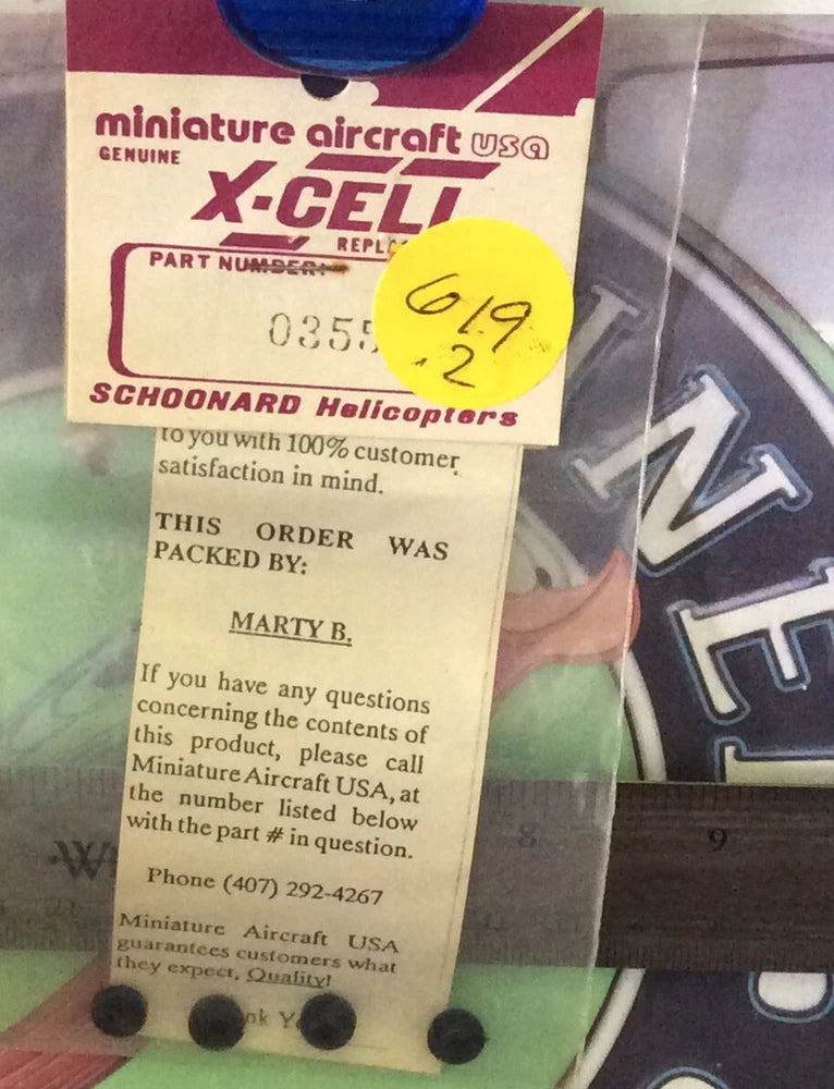 Miniature RC helicopter part in labeled package, includes small black parts
