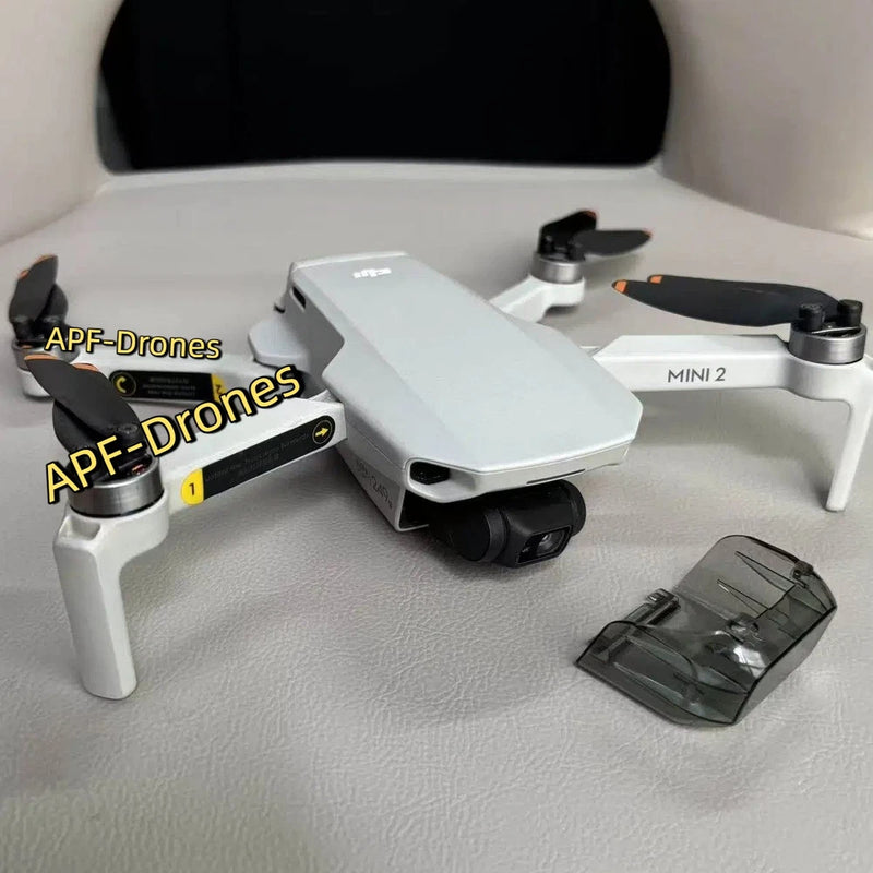 White DJI Mini 2 drone with propellers and gimbal camera protector