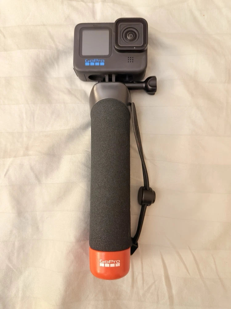 GoPro HERO10 action camera with orange floating handle, gray body and lens mount